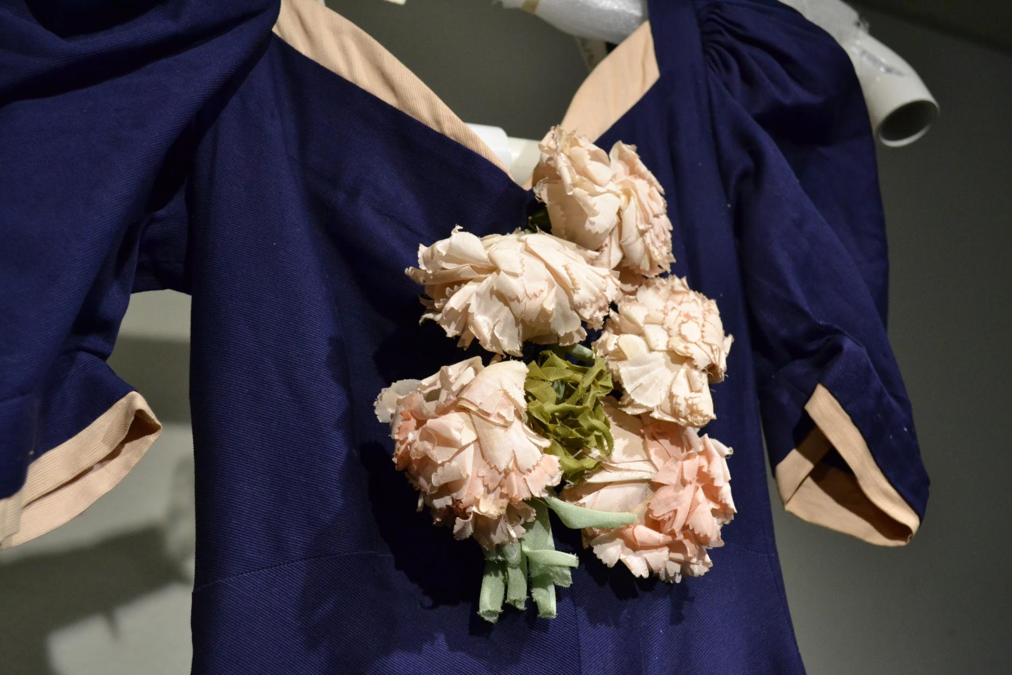 Detail of floral applique on floor-length navy and pink gown. 2003.31.05