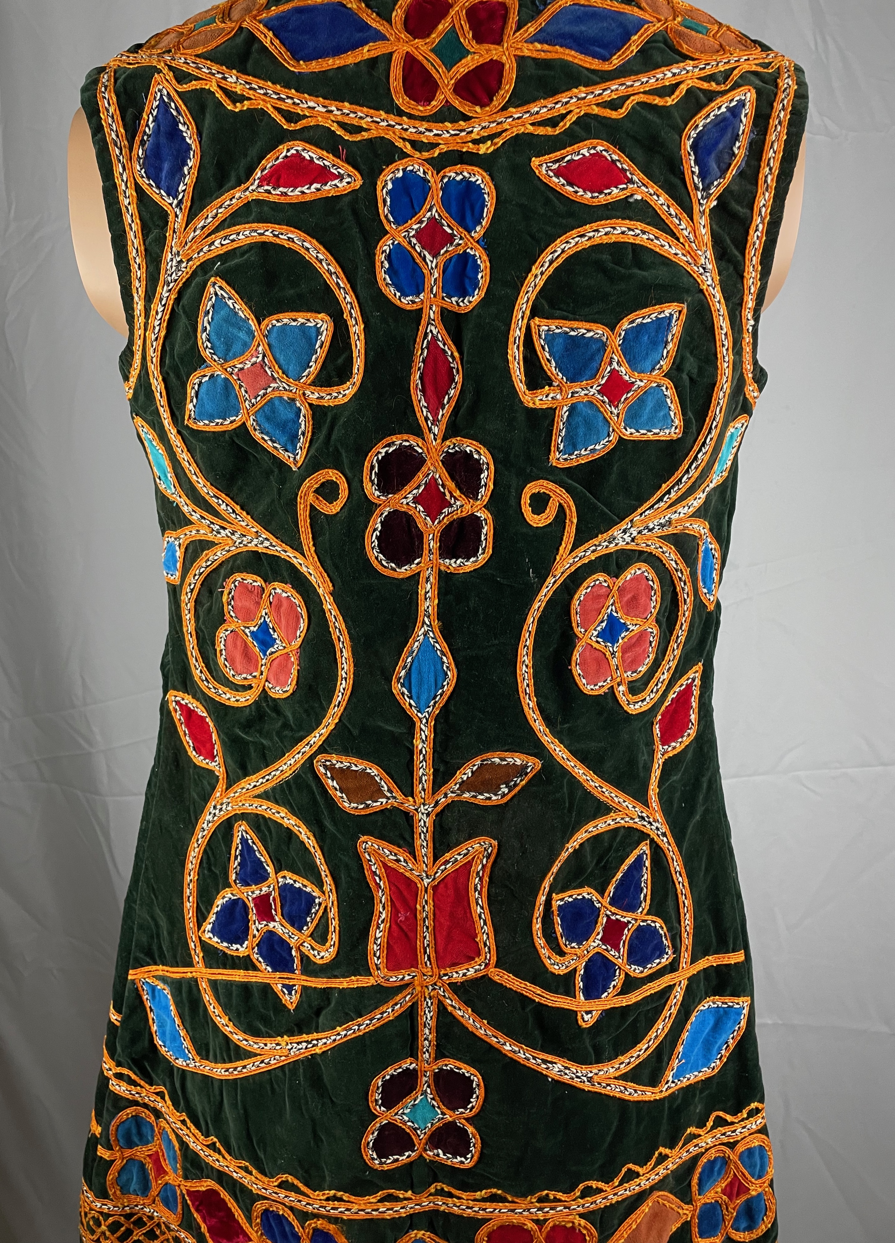 Black vest with gold vine details and blue and red flowers